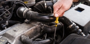 Mechanic checking oil in car engine
